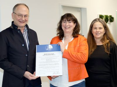 Übergabe BGW-Gütesiegel: Professor Dr. med. Michael Masanneck (rechts), Vorstand des KfH, erhält das BGW-Gütesiegel aus den Händen der BGW-Vertreterinnen Anja Wiebensohn-Jagla (Mitte) und Sandra Herrgesell (links) – ein Zeichen für gelebte Qualität und Engagement.